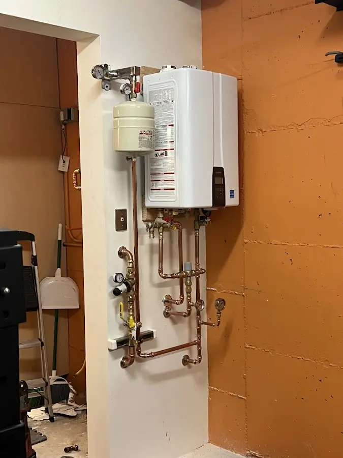 Plumbing technician inspecting water heater connections in Orting